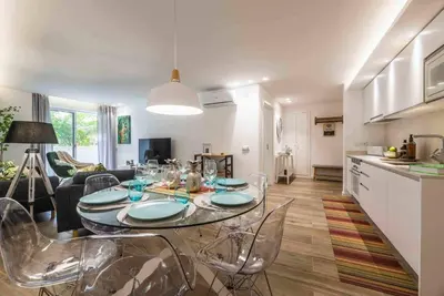 a dining room and living room with a table and chairs at Downtown Albufeira 3-Bedroom Luxury Apartment in Albufeira
