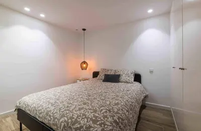 a bedroom with a bed with a white wall at Downtown Albufeira 3-Bedroom Luxury Apartment in Albufeira