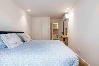 a bedroom with a large bed with white sheets at Downtown Albufeira 3-Bedroom Luxury Apartment in Albufeira