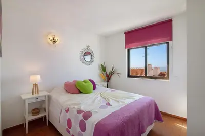 a bedroom with a bed with a green pillow on it at Ouramar Apartment in Areias de São João