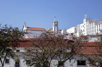 a city skyline with white buildings and a clock tower at Musical Hostel in Albufeira