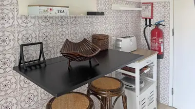 a black table with a chair in a kitchen at Casa AL Reis in Faro