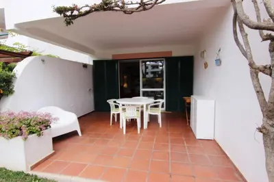 a patio with a table and chairs in a house at Golf Apartment - Solar do Golfe Condominium in Vilamoura