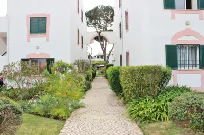 a walkway through a garden in a building at Golf Apartment - Solar do Golfe Condominium in Vilamoura