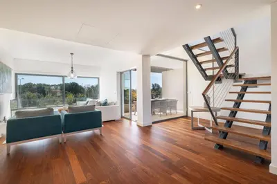 a living room with a staircase and a couch at Apart L'Orange in Vilamoura