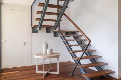 a wooden staircase in a room with a table at Apart L'Orange in Vilamoura