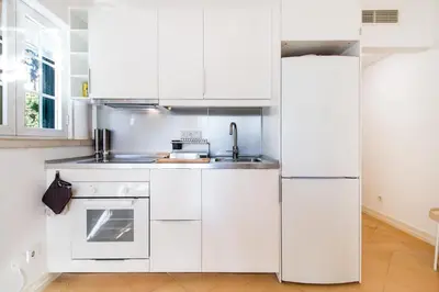 a white kitchen with a sink and a refrigerator at Cypress Villa in Albufeira