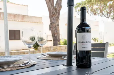 a bottle of wine sitting on a table with glasses at Villa at the beach in Vale do Lobo