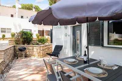 a patio with a table and chairs and an umbrella at Villa at the beach in Vale do Lobo