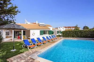 a villa with a swimming pool with chairs and an umbrella at Villa Casa Calma by Villa Plus in Albufeira