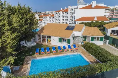 an aerial view of a swimming pool with chairs and a building at Villa Casa Calma by Villa Plus in Albufeira