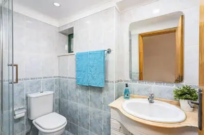 a bathroom with a toilet and a sink and a mirror at Villa Casa Calma by Villa Plus in Albufeira