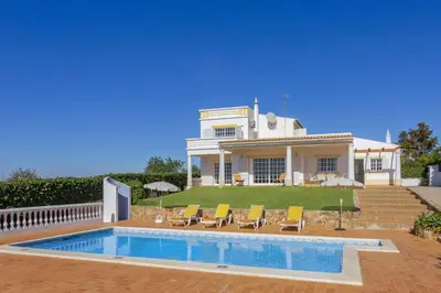 a house with a swimming pool in front of it at Villa Colina do Sol by Villa Plus in Paderne