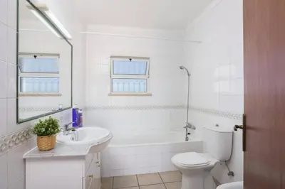 a white bathroom with a toilet and a sink at Villa Colina do Sol by Villa Plus in Paderne
