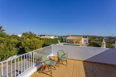 a balcony with two chairs and a table at Villa Colina do Sol by Villa Plus in Paderne