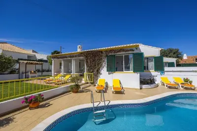 a villa with a swimming pool and a house at Villa Pinheiro Oura by Villa Plus in Albufeira