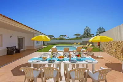 a patio with a table and chairs and a fireplace at Villa Quinta dos Abacates by Villa Plus in Olhos de Água