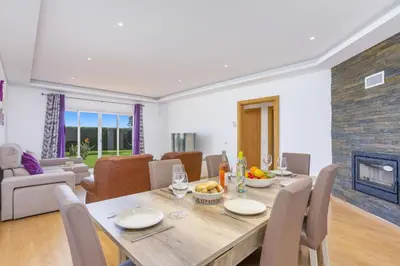 a patio with a table and chairs and a pool at Villa Quinta dos Abacates by Villa Plus in Olhos de Água