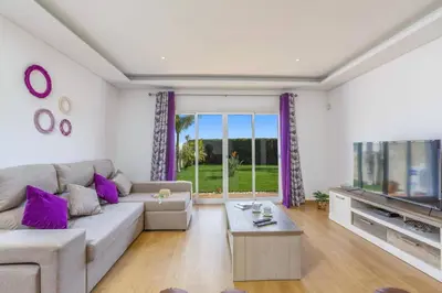 a living room with a couch and a tv at Villa Quinta dos Abacates by Villa Plus in Olhos de Água