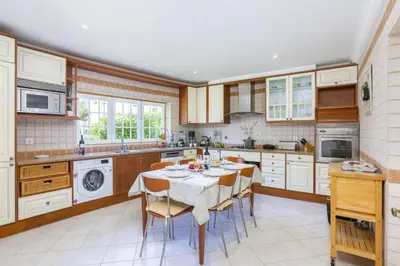 a kitchen with a table and chairs in it at Villa Quinta dos Bicos by Villa Plus in Albufeira