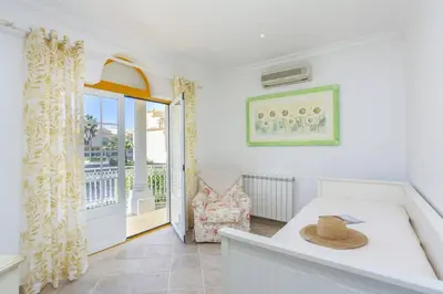 a room with a table and a chair and a balcony at Villa Quinta dos Bicos by Villa Plus in Albufeira