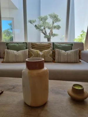 a living room with a couch and a vase on the floor at Cosy Guest House - Villa das Alfarrobas in Algoz