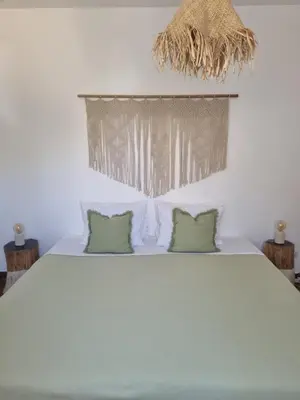 a bedroom with a bed with two green pillows at Cosy Guest House - Villa das Alfarrobas in Algoz