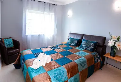 a bedroom with a bed and a chair and a window at Tatiana 1 bedroom apartment in Albufeira