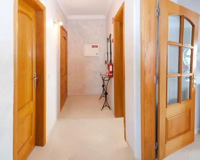 a hallway with two wooden doors and a tile floor at Tatiana 1 bedroom apartment in Albufeira