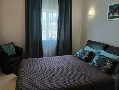 a bedroom with a bed and a chair and a window at Tatiana 1 bedroom apartment in Albufeira