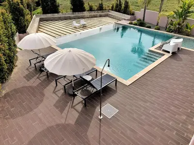 a swimming pool with two umbrellas and a table and chairs at DIANA BEACH HOUSE in Albufeira