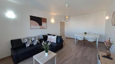 a living room with a black couch and a table at Albufeira Oura Beach Apartment in Albufeira