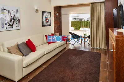 a living room with a white couch with red pillows at Apartamento em Albufeira a 10 min da praia * 50070/AL in Albufeira