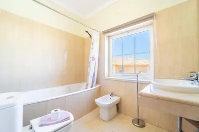 a bedroom with a bed and a chair and a window at Villa Galé in Guia