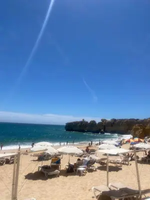 a beach with chairs and umbrellas and the ocean at Albufeira Praia São Rafael Sun Apartment in Albufeira