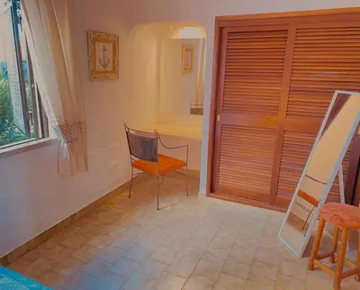 a room with a chair and a window and a door at Albufeira Praia São Rafael Sun Apartment in Albufeira