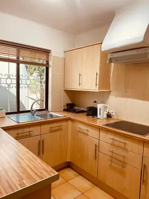 a kitchen with wooden cabinets and a sink at Albufeira Praia São Rafael Sun Apartment in Albufeira
