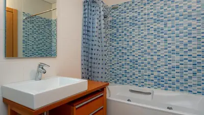 a bathroom with a white sink and a shower at Parque Atlântico Apartment T1 in Quarteira