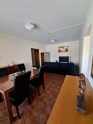 a waiting room with tables and chairs and a couch at Flat Caballero in Guia