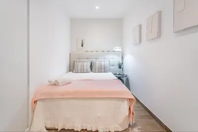 a bedroom with a bed with a pink blanket at Palmeiras Apartment - 19A by HelloVacations in Albufeira