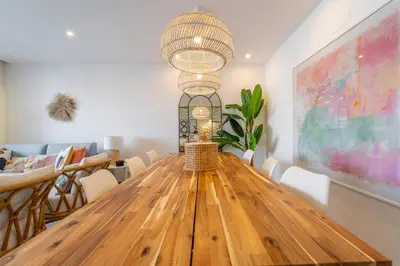 a dining room with a wooden table and a large chandelier at Palmeiras Apartment - 19A by HelloVacations in Albufeira