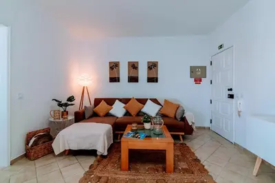 a living room with a couch and a table at Holiday 1 Bed Apartment with pool in Albufeira in Albufeira