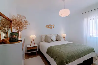a white bedroom with a bed and two lamps at Holiday 1 Bed Apartment with pool in Albufeira in Albufeira
