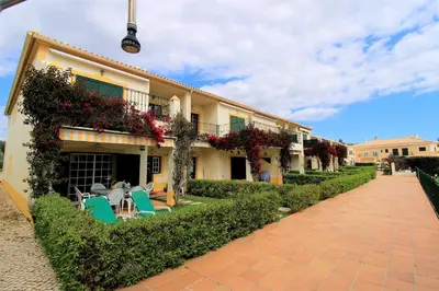 a building with chairs and flowers next to a sidewalk at Vilamoura MiraGolf With Pool by Homing in Vilamoura