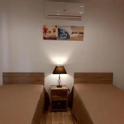 a room with two beds and a night stand with a lamp at Quinta Vita- Vila Laranja in Almancil