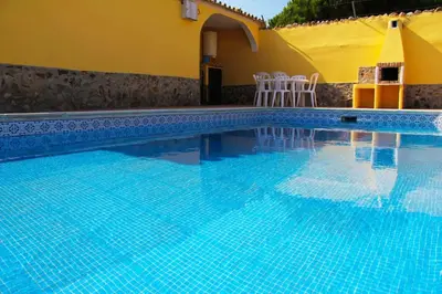 a swimming pool with blue water in front of a house at Quinta Vita- Vila Laranja in Almancil
