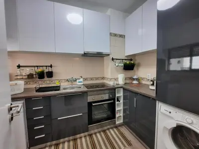 a kitchen with white cabinets and a sink and a dishwasher at Casa Cerro Sol in Albufeira
