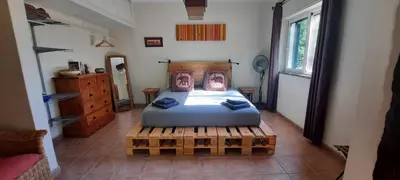 a bedroom with a bed and a wooden bed frame at Rural Peace in the Algarve - Private Room with kitchenette and bathroom in Aldeia dos Matos