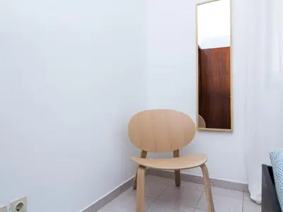 a wooden chair in a room with a mirror at Villa Bel Mar by Stay ici Algarve Holiday Rental in Guia