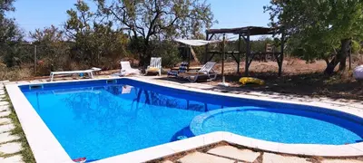 a swimming pool in a yard with chairs and a gazebo at Quinta do Amendoal o melhor da Natureza no Algarve in Terras Novas